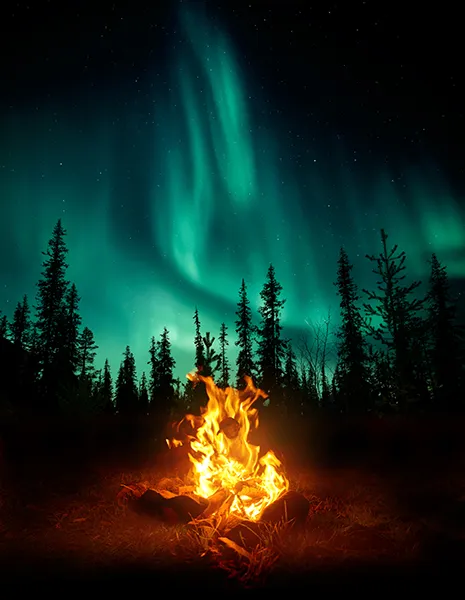 Brûlage des peurs - un feu de camp brûle sous une aurore boréale